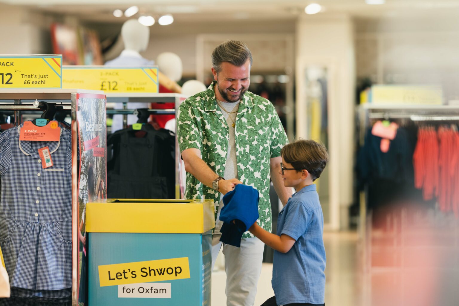 A father and son donating clothes to the new 'Let's Shwop' box in M&S. 