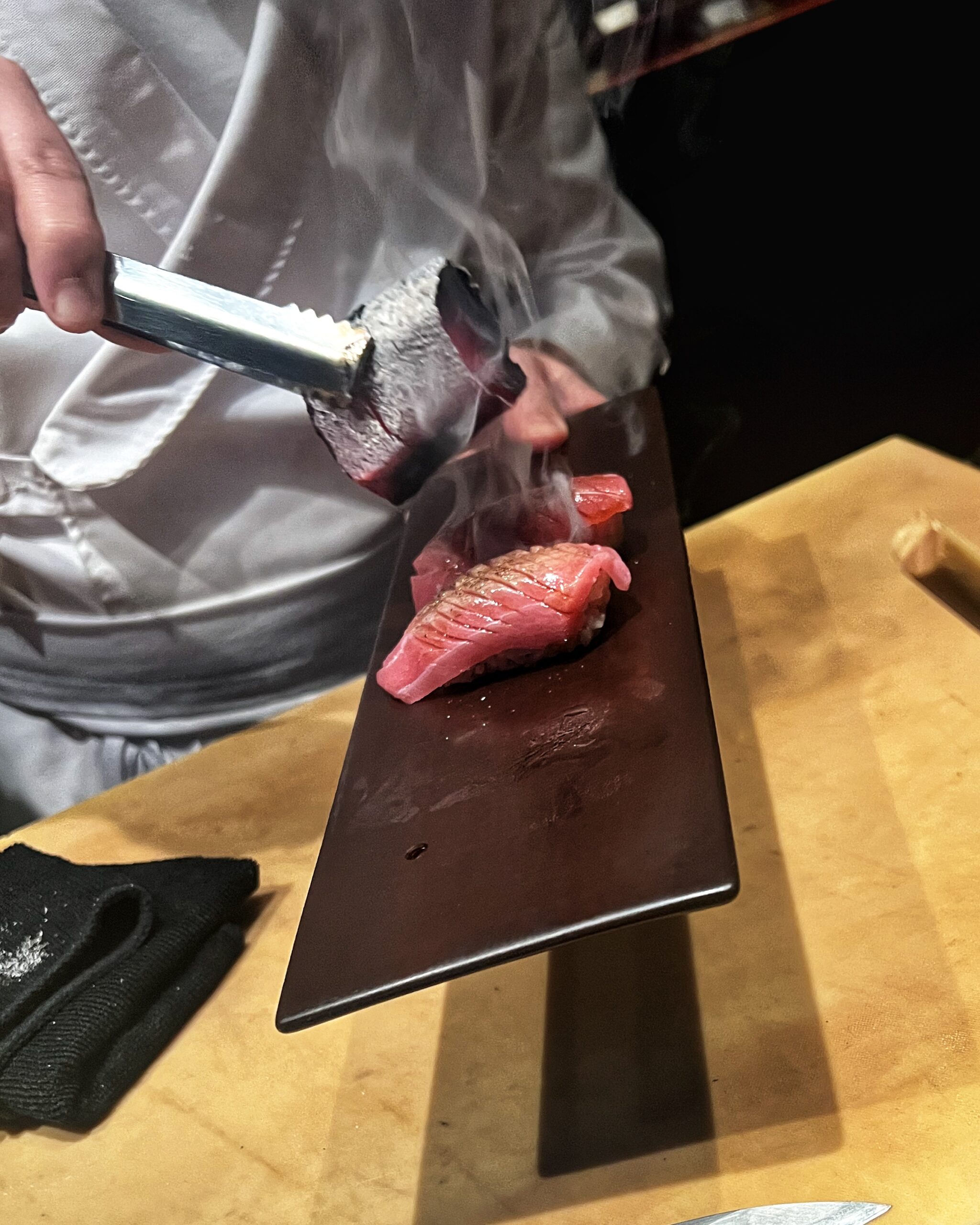 Musu's head chef searing the Chu-toro in front of diners