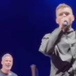Gary Neville and Jamie Carragher get local Manchester musician Ewan Sims on stage at O2 Apollo