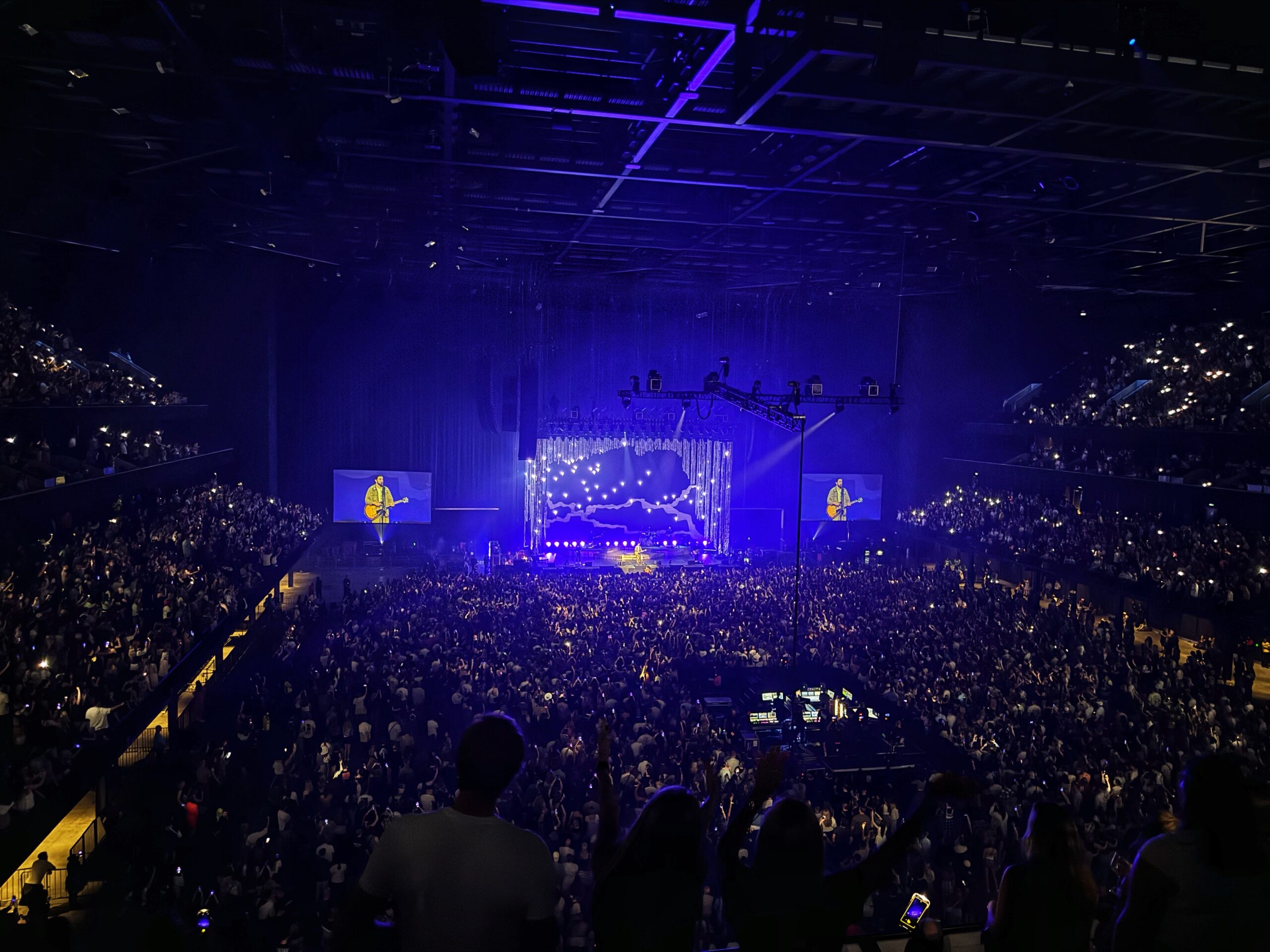 Noah Kahan performing on stage infront of thousands of people at co-op live in Manchester