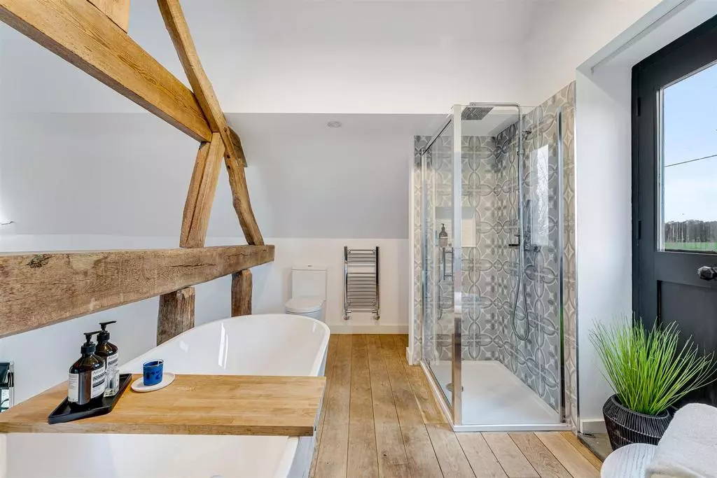 The bath and shower in the mezzanine en-suite overlooking the bedroom.