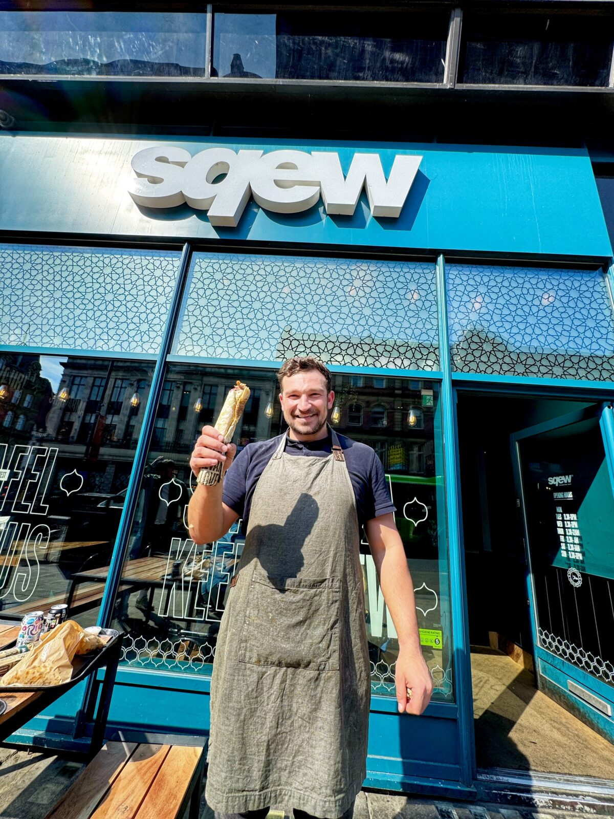 Owner of SQEW standing outside of his eatery in Leeds. 