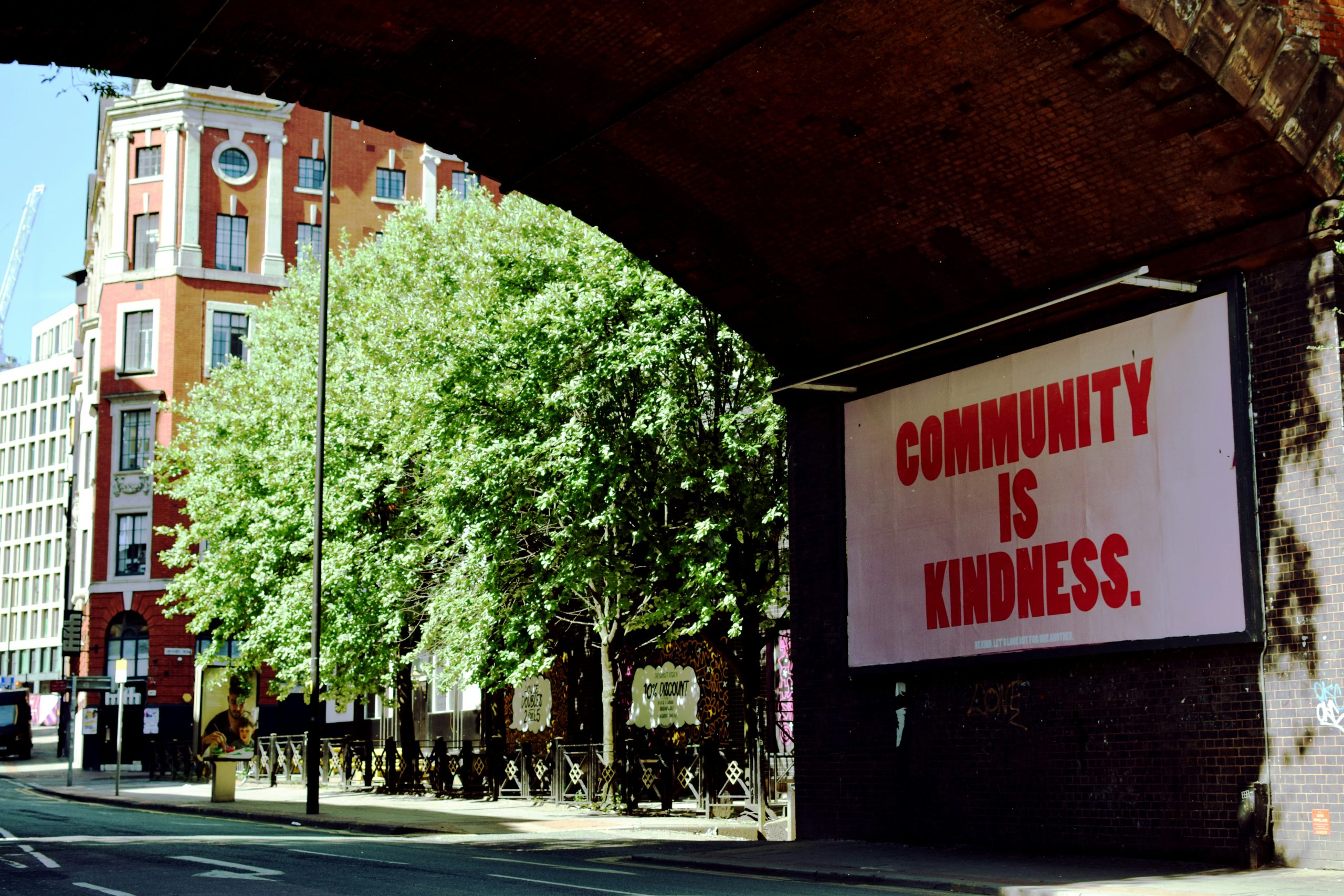 Community is Kindness billboard in Manchester city centre